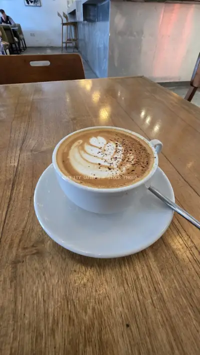Delicious Latte Art Coffee on Wooden Table in Bali Cafe - stock photo