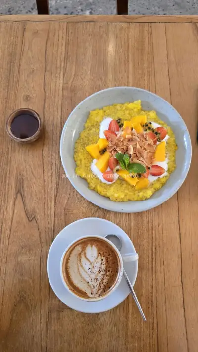 Vibrant Tropical Breakfast Bowl and Latte on Wooden Table - stock photo