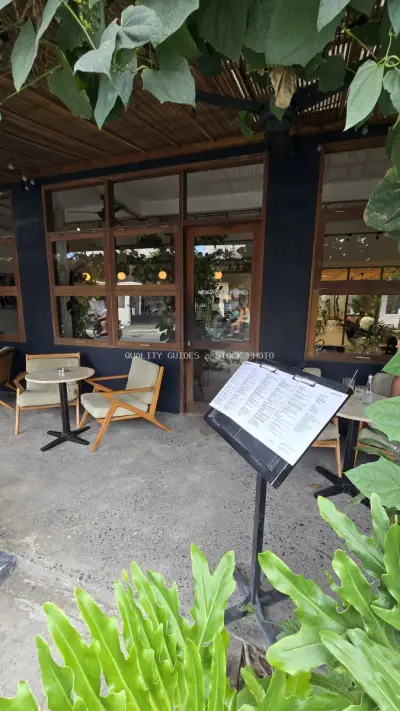 Modern Cafe Exterior with Outdoor Seating and Tropical Greenery in Bali - stock photo