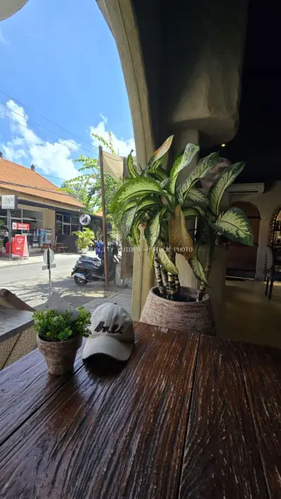 Bali Cafe View: Relaxed Street Scene with Travel Cap - stock photo