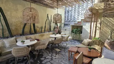 Bohemian Outdoor Cafe Seating with Wicker and Cacti in Bali - stock photo