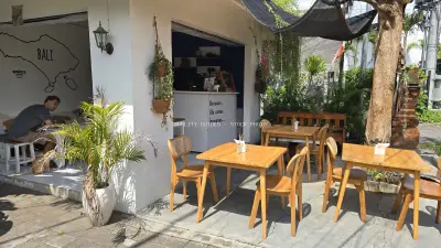Tropical Outdoor Cafe in Bali with Man Working - stock photo
