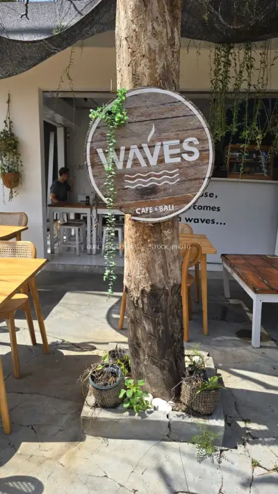 Waves Cafe Bali Entrance with Rustic Wooden Sign and Outdoor Seating - stock photo