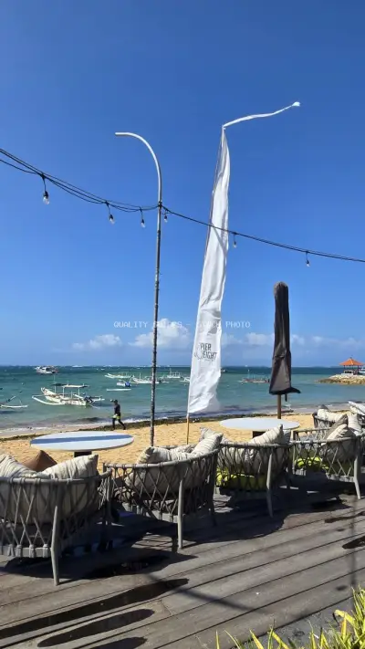 Bali Beach Club Lounge with Ocean View and Traditional Boats - stock photo