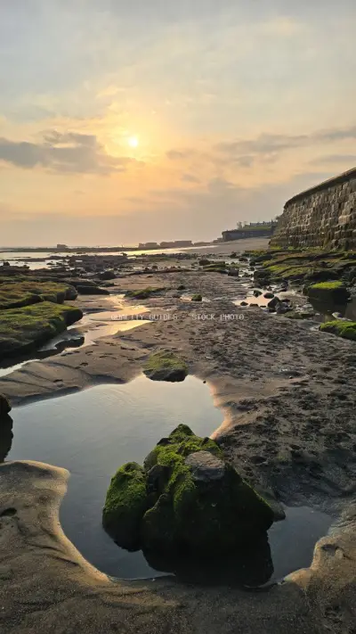 Golden Sunset over Cemagi Beach Bali with Mossy Rocks - stock photo