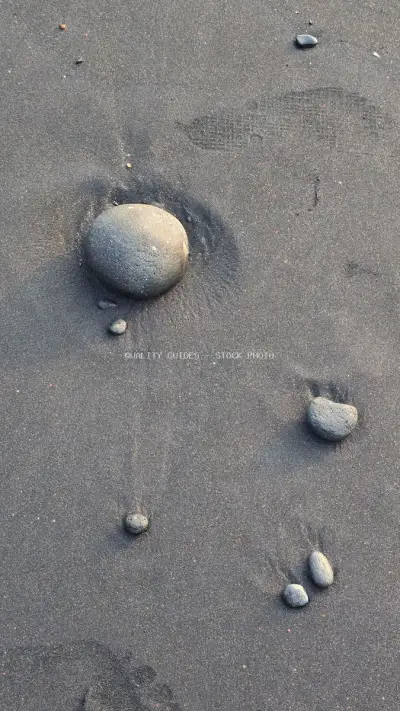 Black Sand Beach Texture with Smooth Pebbles, Natural Background - stock photo