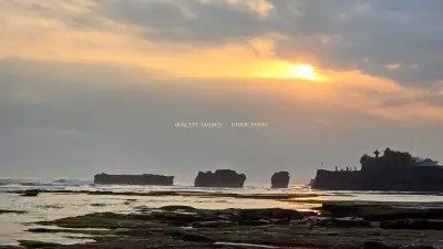 Dramatic Sunset Over Mengening Beach Sea Temple in Bali - stock photo