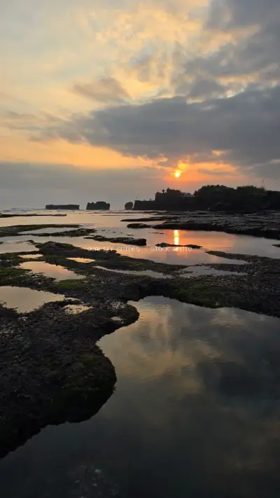Dramatic Sunset over Mengening Beach, Bali with Reflecting Tide Pools - stock photo