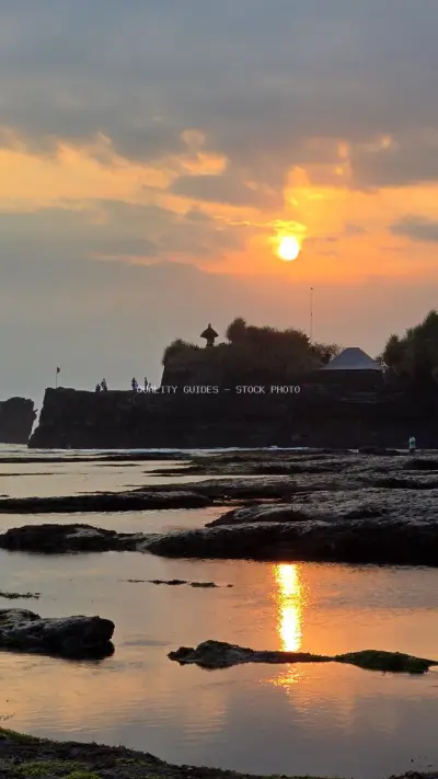 Balinese Temple Sunset at Mengening Beach, Tranquil Ocean View - stock photo
