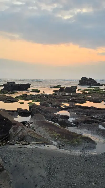 Mengening Beach Sunset: Volcanic Rocks and Tidal Pools in Bali - stock photo