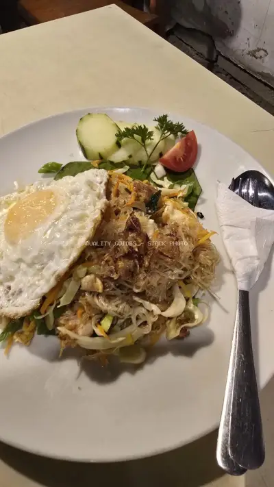 Authentic Indonesian Noodle Dish with Fried Egg and Fresh Vegetables - stock photo