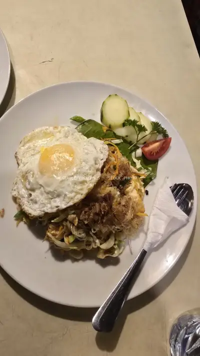Authentic Indonesian Fried Noodles with Fried Egg and Garnish in Bali - stock photo