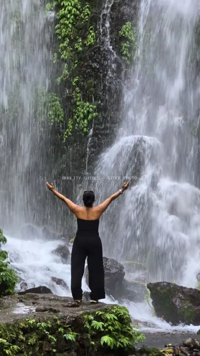 Woman with Arms Raised at Tropical Waterfall Bali - stock photo