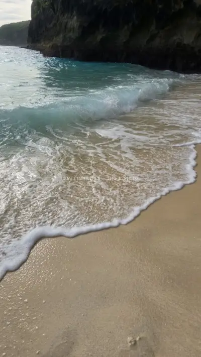 Kelingking Beach Bali turquoise waves sandy shore - stock photo