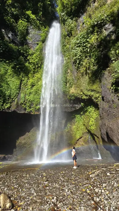 Traveler at Pucak Manik Waterfall Bali with Rainbow - stock photo