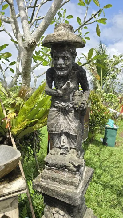 Traditional Balinese Stone Statue in Lush Garden Setting - stock photo
