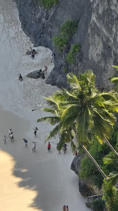 Aerial view Diamond Beach Bali with tourists and palm trees - stock photo