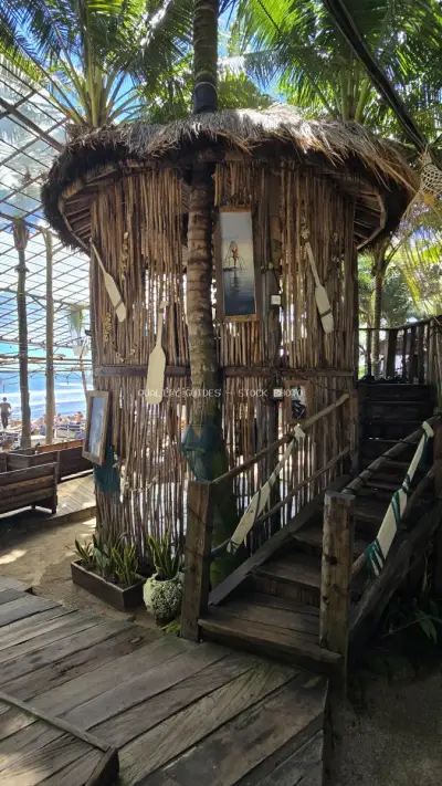 Tropical Tiki Bar Hut with Palm Trees Bali Beach Club - stock photo