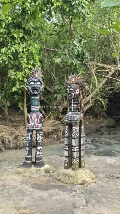 Traditional Balinese Wooden Statues in Jungle Stream Setting - stock photo