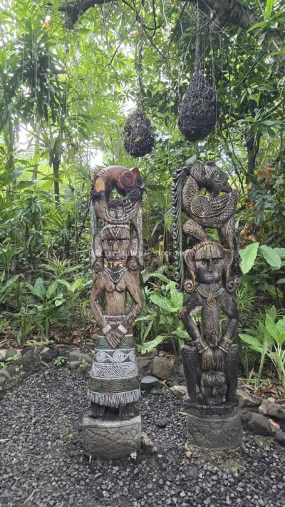 Balinese Wooden Statues in Tropical Garden Setting - stock photo