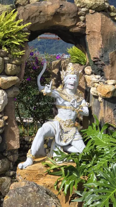 Balinese Temple Guardian Statue Through Stone Archway - stock photo