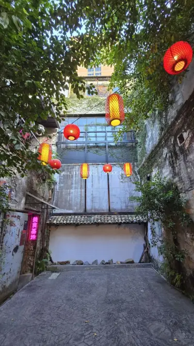Red Lanterns Hanging in Lush Green Alley Courtyard - stock photo