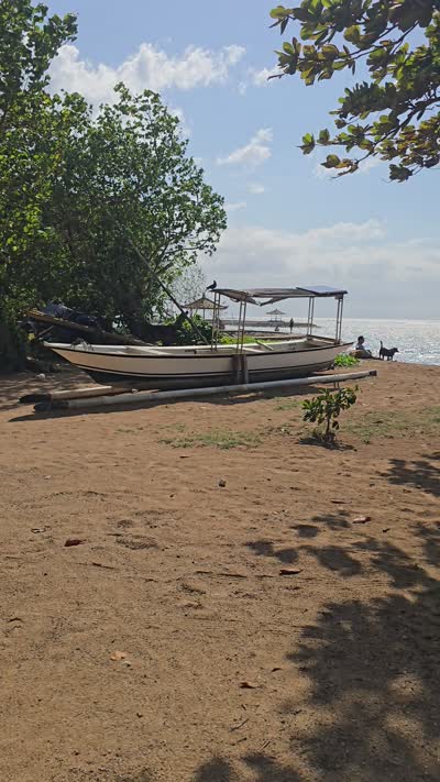 Tracking shot from Karang Beach with boats to an ornate traditional Balinese door with gold carvings. - stock photo