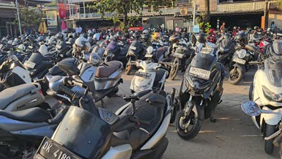 Crowded parking lot in Bali with hundreds of parked scooters and motorbikes, panning shot. - stock photo