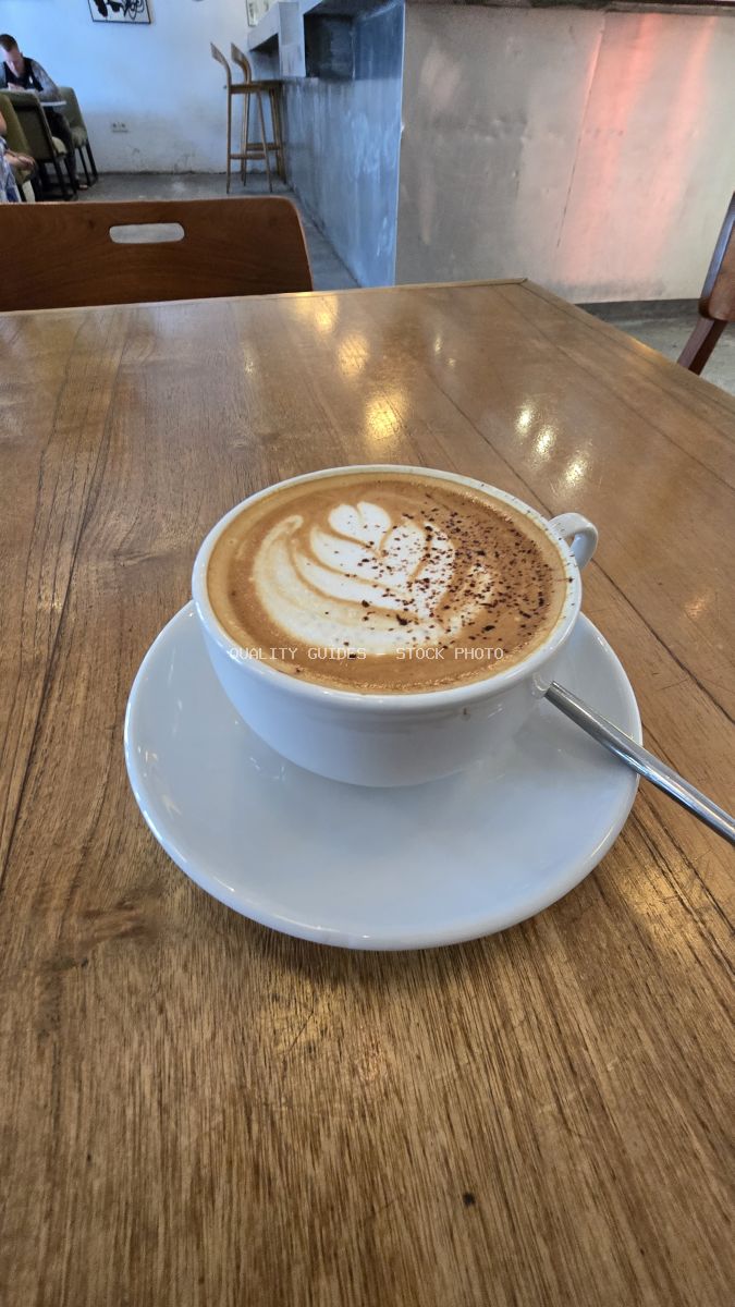 Latte art coffee cup on a wooden table in a modern cafe. - stock photo