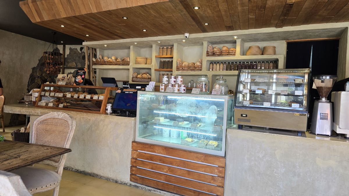 Interior of a rustic modern bakery in Bali with display cases, shelves of bread, and wooden decor. - stock photo