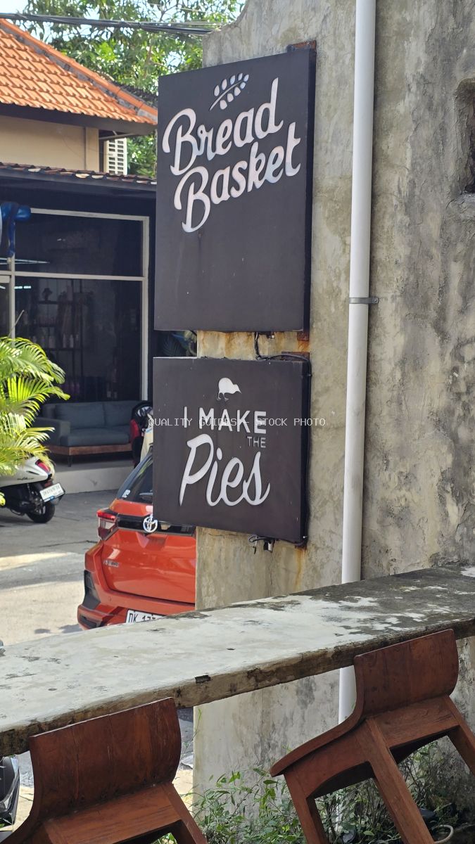 Bread Basket bakery sign in Bali, featuring 'I Make The Pies' text and a kiwi bird icon. - stock photo