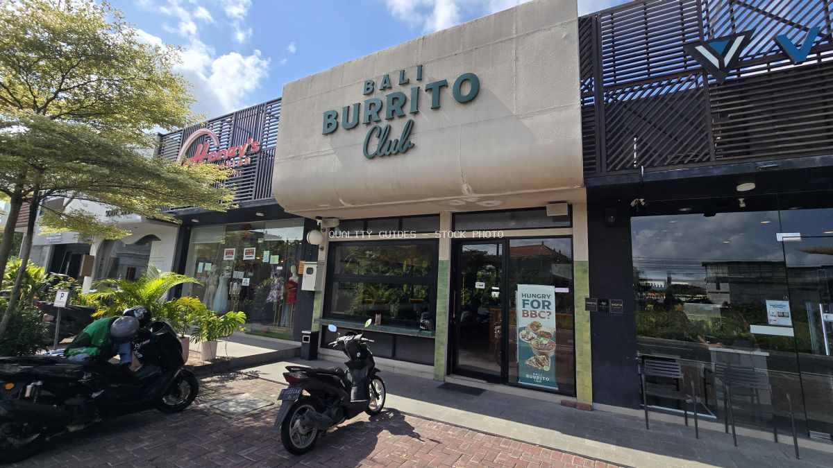 Exterior view of Bali Burrito Club Mexican restaurant in Canggu, Bali, with parked scooters and tropical plants. - stock photo