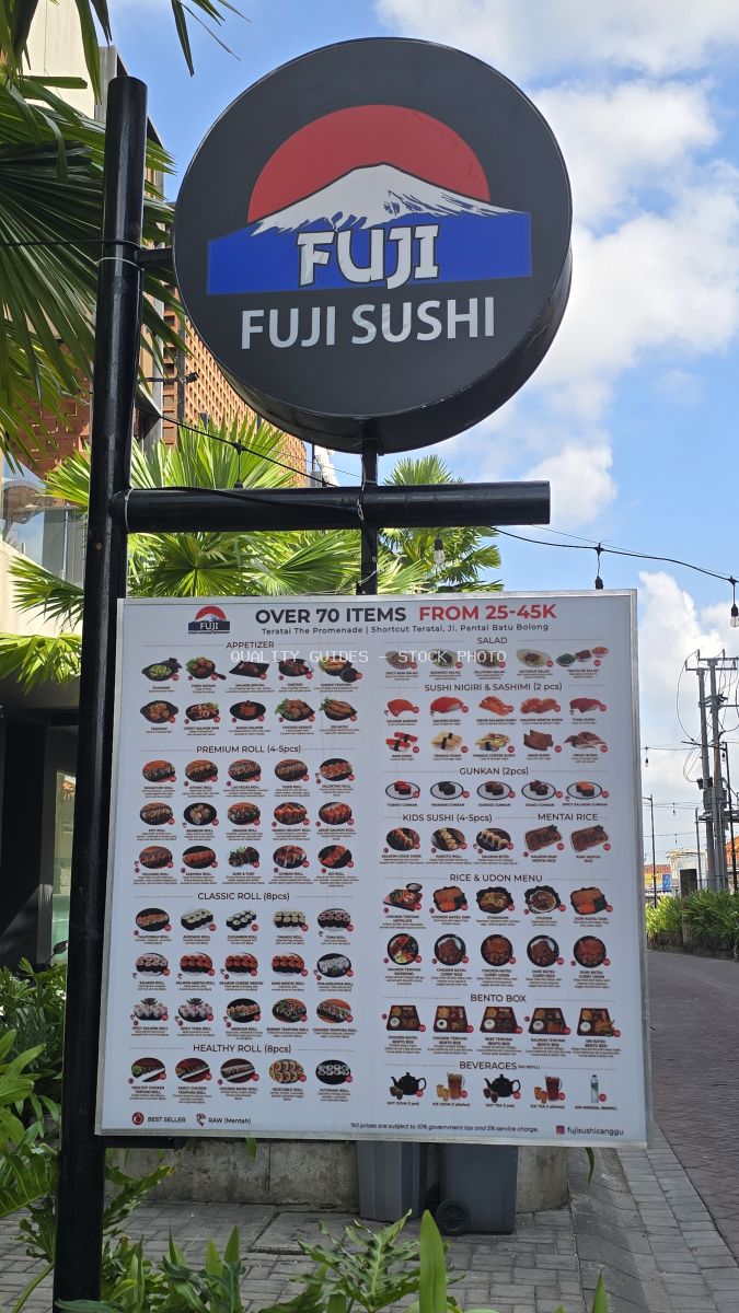 Fuji Sushi restaurant sign and menu board with Mount Fuji logo against a blue sky in Canggu, Bali. - stock photo