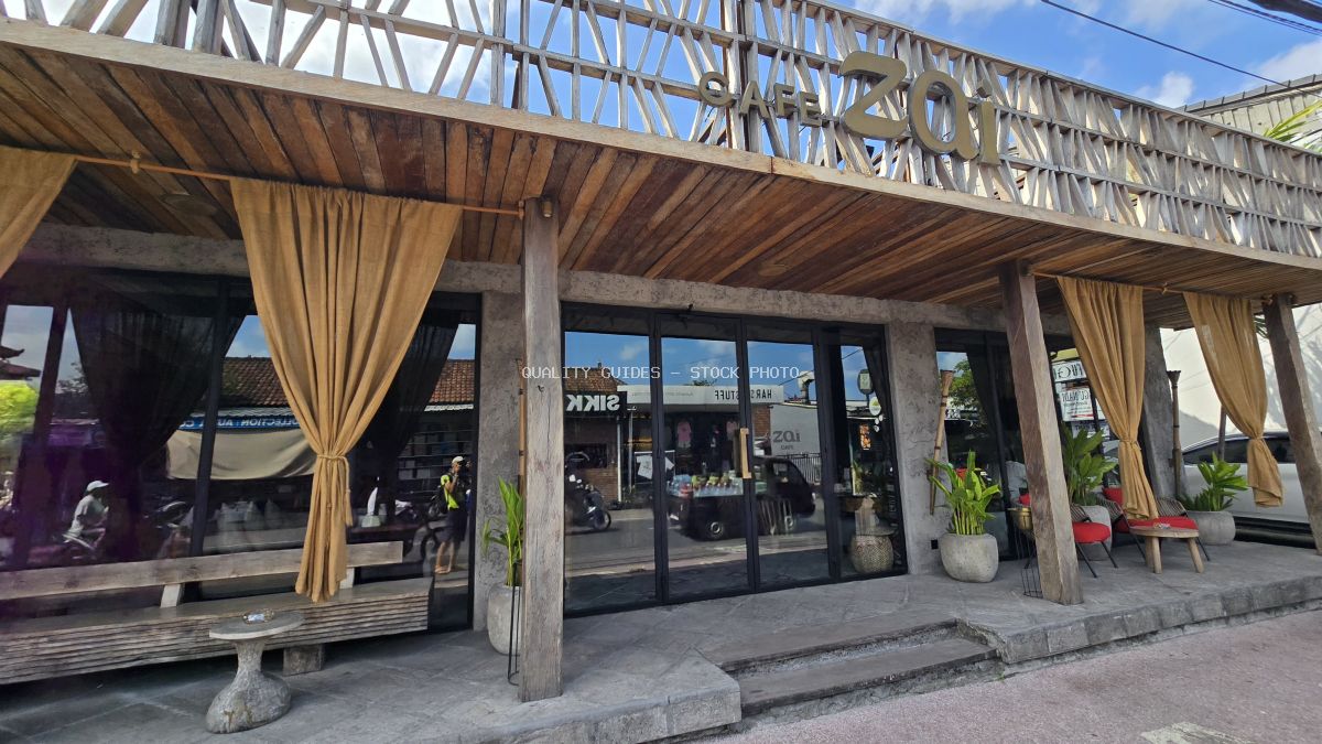 Exterior of Cafe Zai in Bali, a modern building with wooden facade, glass doors, and outdoor seating. - stock photo