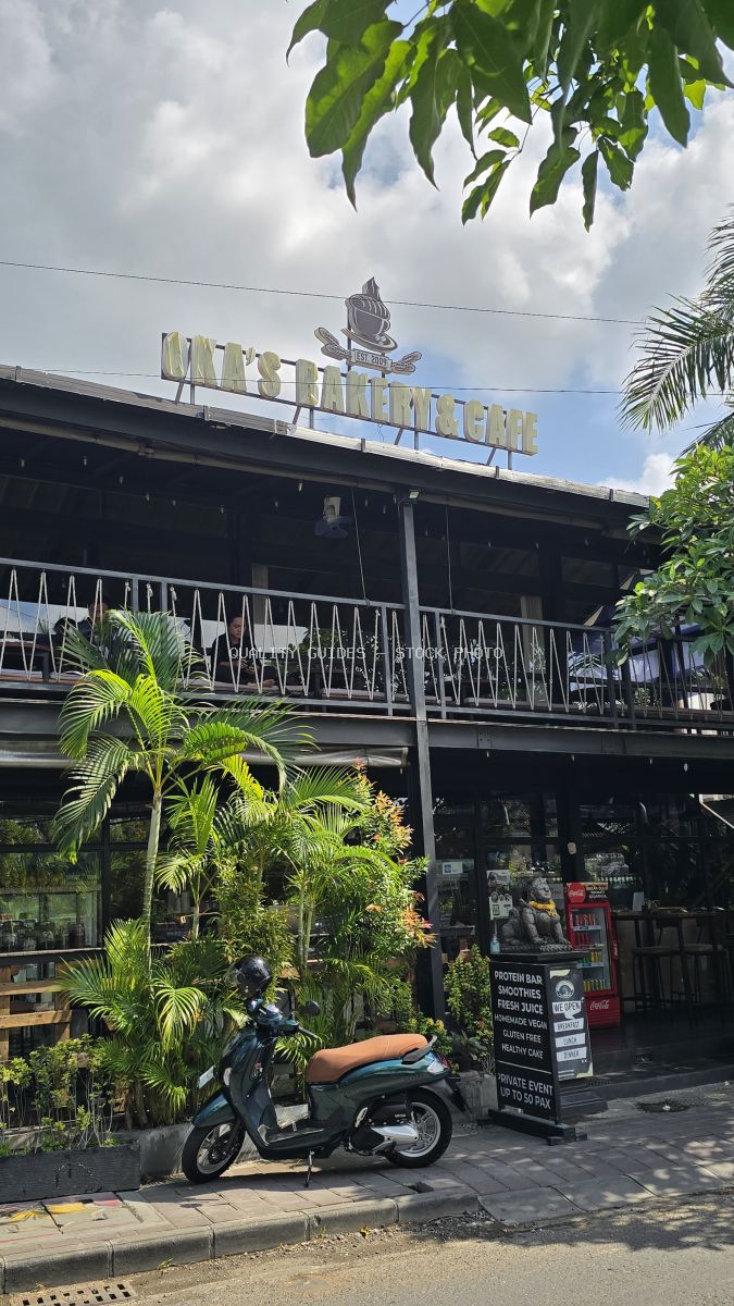 Oka's Bakery & Cafe exterior in Bali with a scooter and tropical plants. - stock photo
