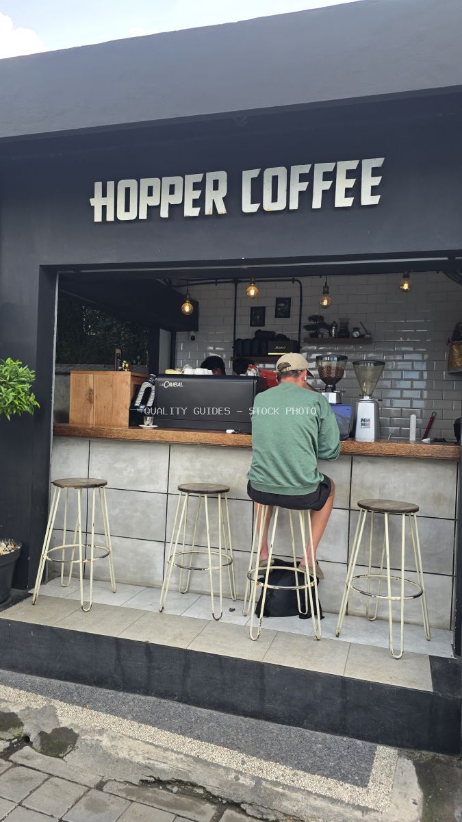 Exterior view of Hopper Coffee in Bali with a person sitting at the counter. - stock photo