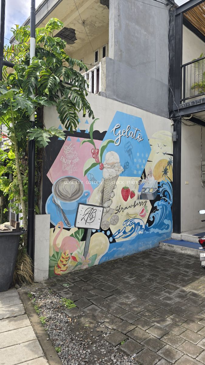 Colorful mural depicting coffee, gelato, strawberries, and a flamingo on a wall in Canggu, Bali. - stock photo