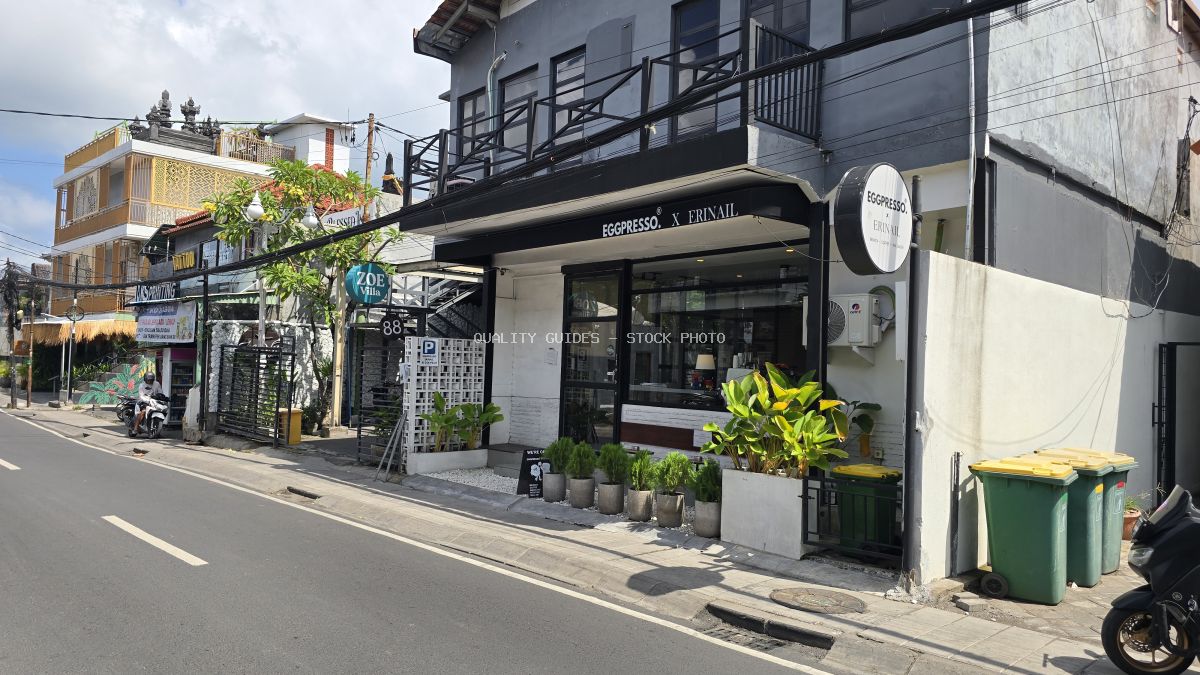 Exterior view of Eggpresso Canggu cafe and nail salon in Bali, with a street and other buildings. - stock photo