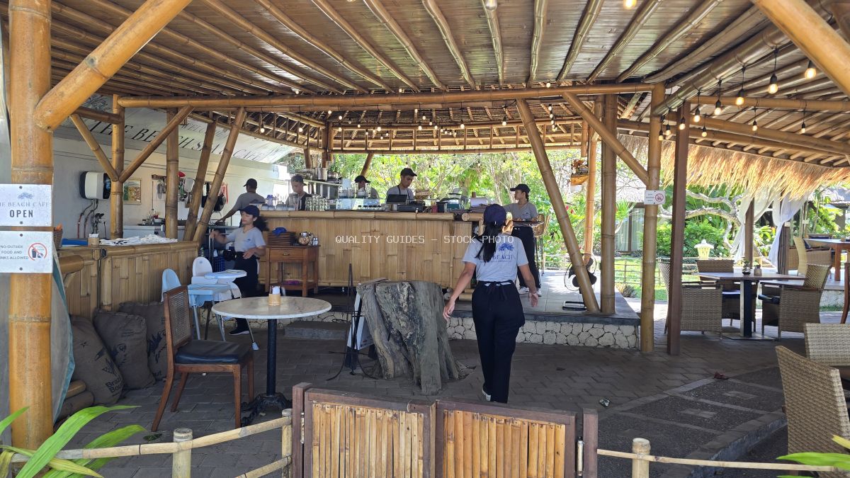 Interior of a tropical bamboo cafe with staff working behind the bar and walking through the seating area. - stock photo