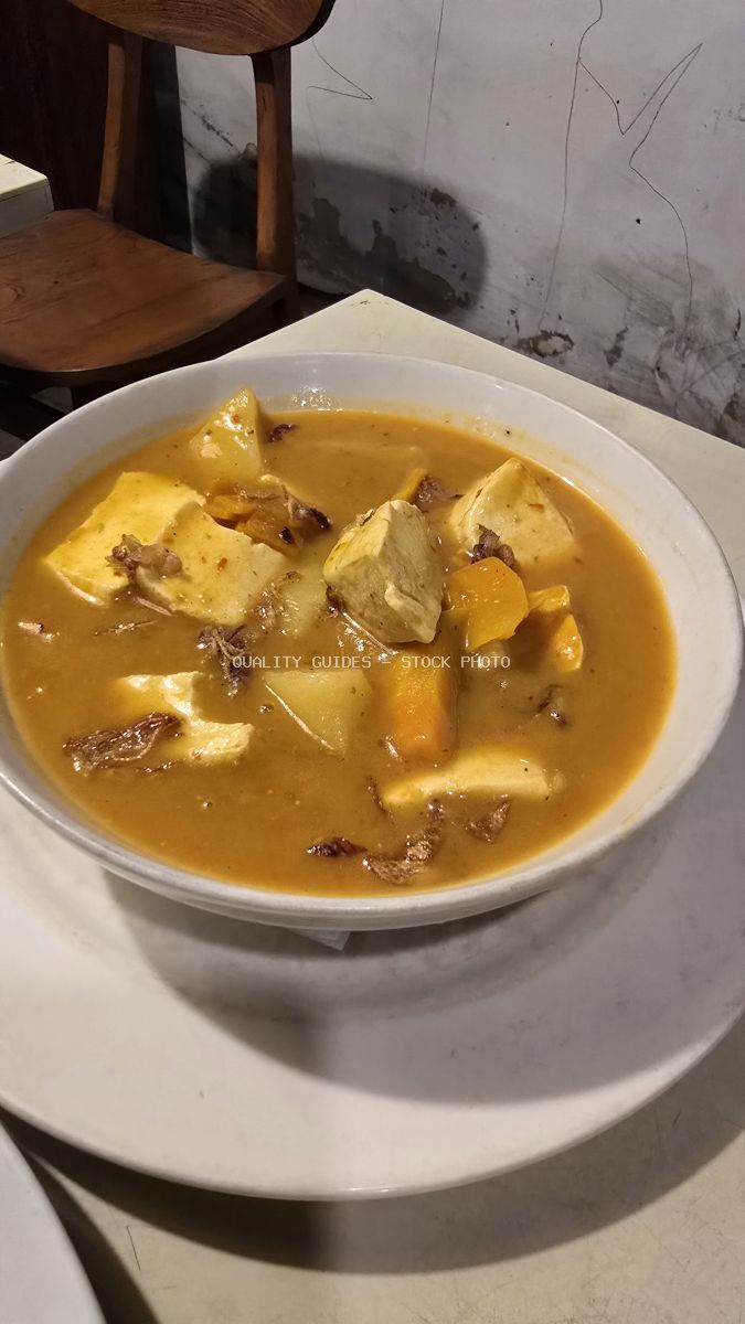 Bowl of Indonesian tofu and vegetable curry with potatoes and crispy shallots. - stock photo