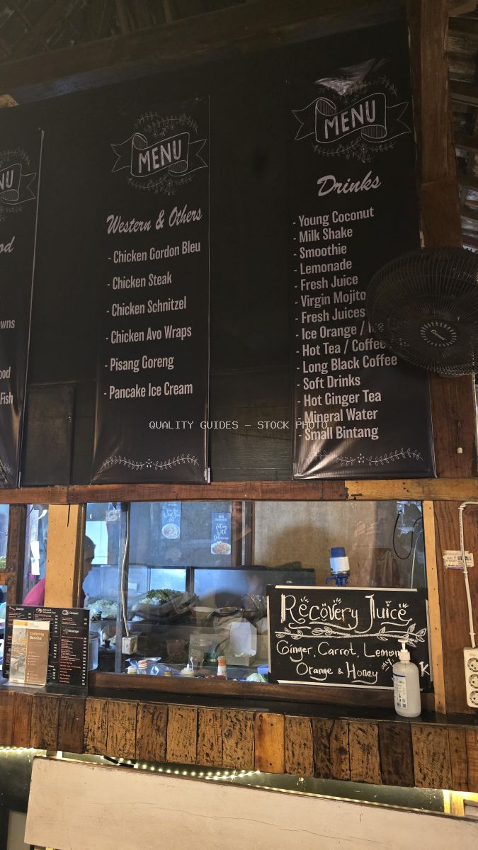 Restaurant menu board in Bali showing food and drink options like chicken dishes, local snacks, and various beverages. - stock photo