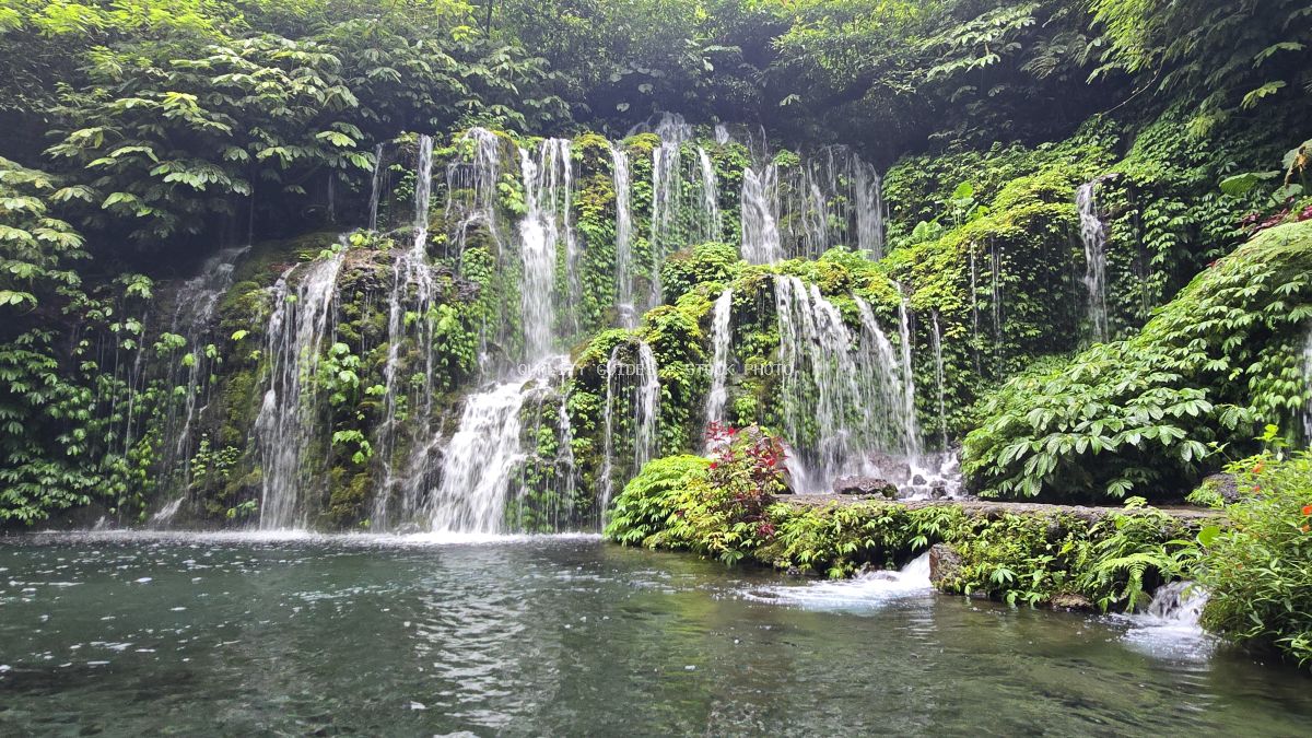 Multi-tiered waterfall in lush tropical jungle with emerald pool, Banyu Wana Amertha Waterfall, Bali - stock photo