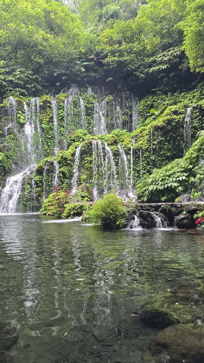 Multi-tiered waterfall with cascading streams in lush green jungle, Banyu Wana Amertha Waterfall, Bali - stock photo