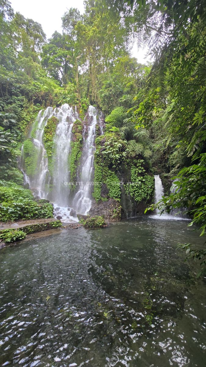 Multi-tiered waterfall in lush tropical jungle with emerald pool, Banyu Wana Amertha Waterfall, Bali - stock photo