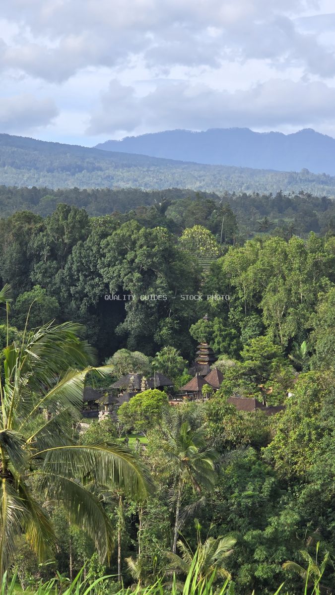 Aerial view of traditional Balinese temple surrounded by dense tropical jungle and mountains in Jatiluwih, Bali - stock photo