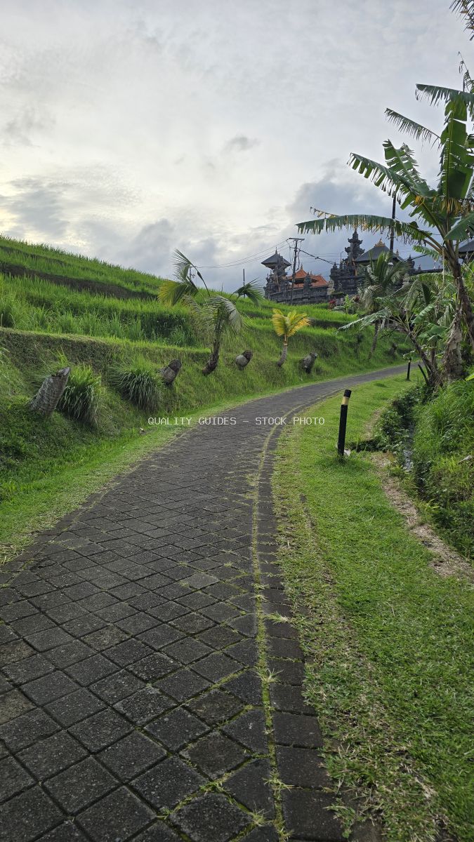 Stone pathway through Jatiluwih Rice Terraces with traditional Balinese temple in background, Bali Indonesia - stock photo
