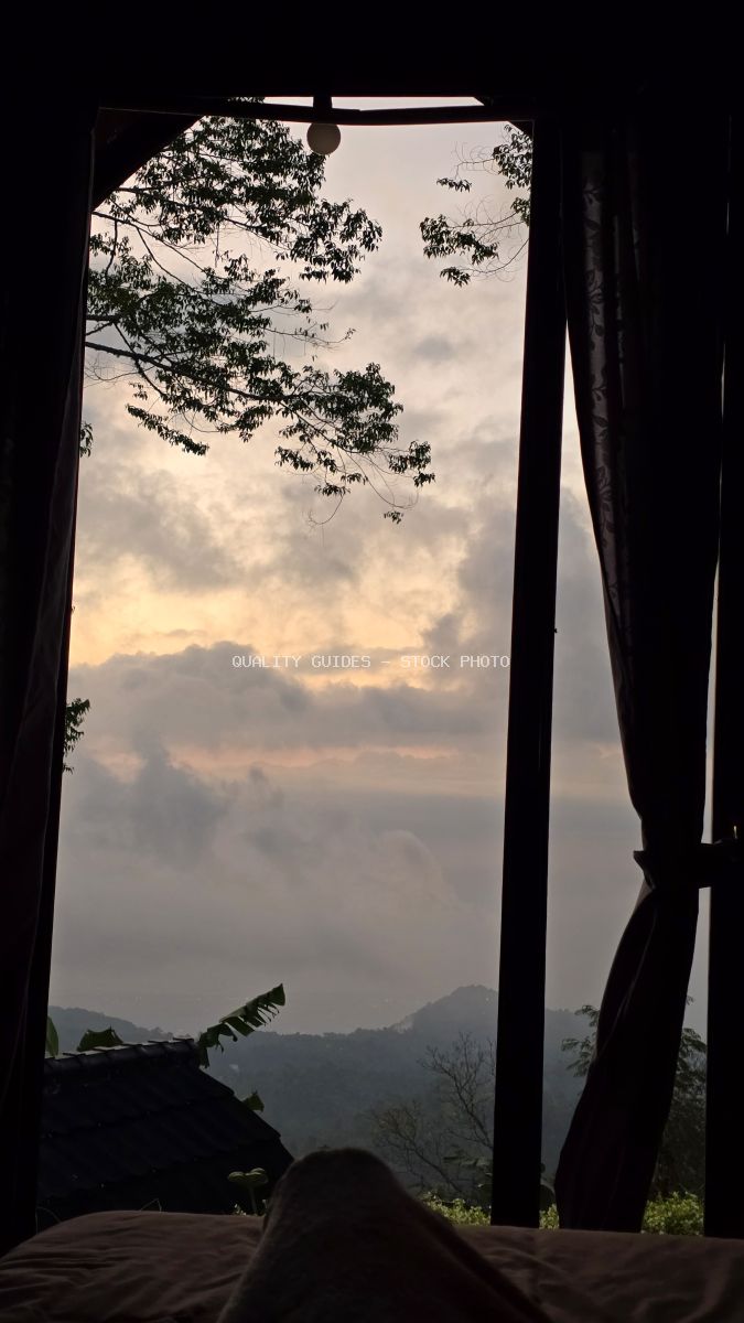View from luxury glamping pavilion overlooking misty mountains at sunset in Bali, Indonesia - stock photo