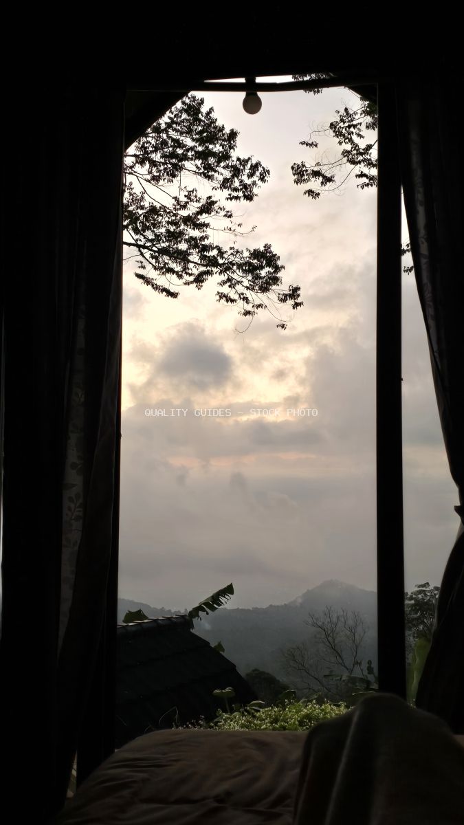 View from luxury glamping tent overlooking misty mountains and tropical landscape in Bali at sunrise - stock photo