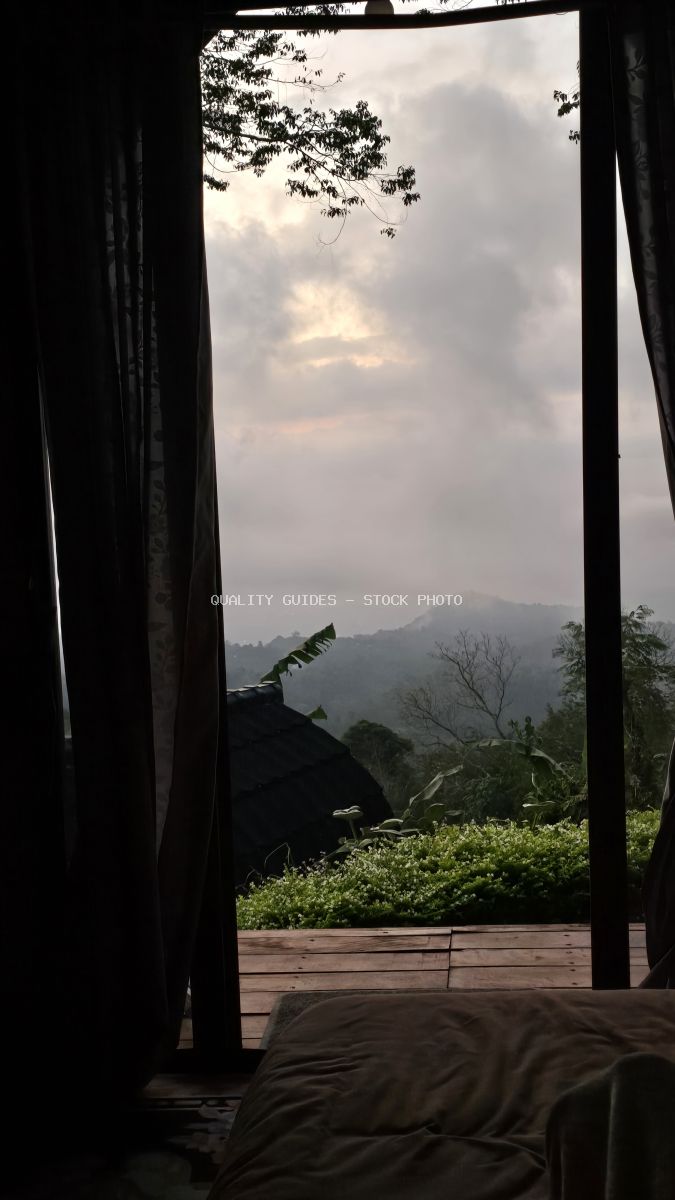 View from luxury glamping tent interior overlooking misty mountain valley and tropical landscape in Bali - stock photo