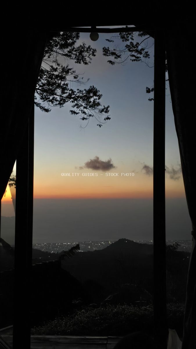 Sunset view from luxury glamping tent in Bali with tropical foliage and valley lights - stock photo